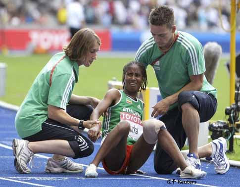 Gelete Burka (C) of Ethiopia is helped by medical staff after crossing the finish line last following a fall in the women's 1500 meters final during the world athletics championships at the Olympic stadium in Berlin, August 23, 2009.