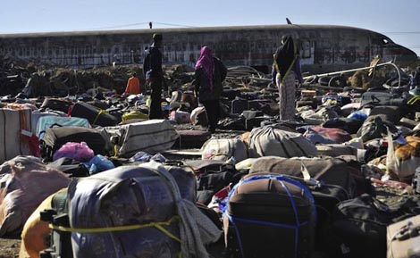 BACK HOME. Ethiopian immigrants returning from Saudi Arabia searching for their luggages among unclaimed bags at Addis Ababa's Bole International Airport, December 10, 2013. AFP/Jenny Vaughan