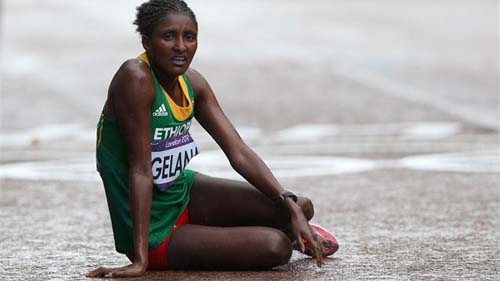 አትሌት ቲኪ ገላና የወርቅ ሜዳሊያ ማግኘቷን ካረጋገጠች በኋላ ዕረፍት ስታደርግ Gold medalist Tiki Gelana of Ethiopia rests at the finish line አትሌት ቲኪ ገላና የወርቅ ሜዳሊያ ማግኘቷን ካረጋገጠች በኋላ ዕረፍት ስታደርግ Gold medalist Tiki Gelana of Ethiopia rests at the finish line