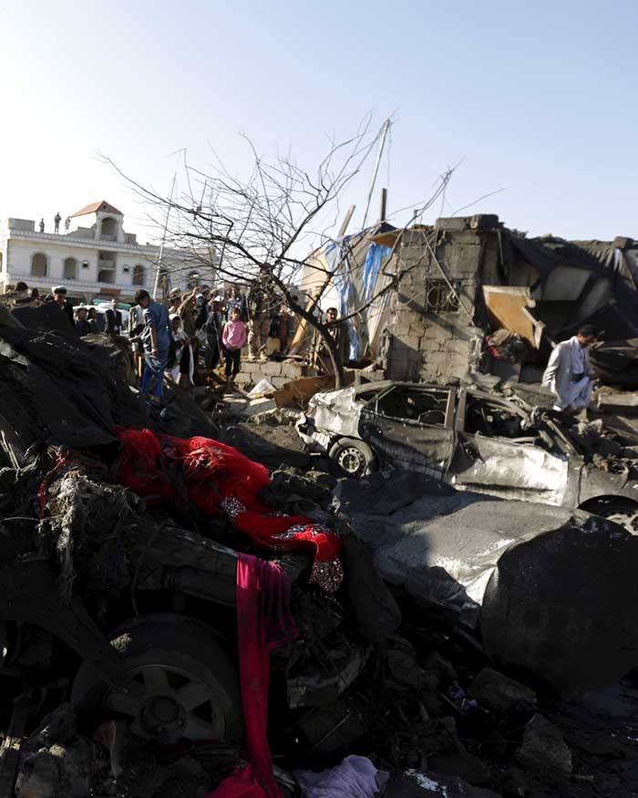 People gather at the site of an air strike at a residential area near Sanaa (Reuters)